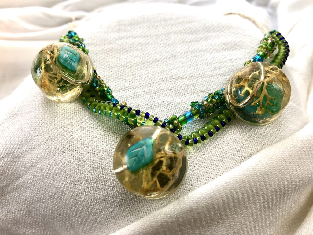 Beaded necklace with natural inclusions in resin