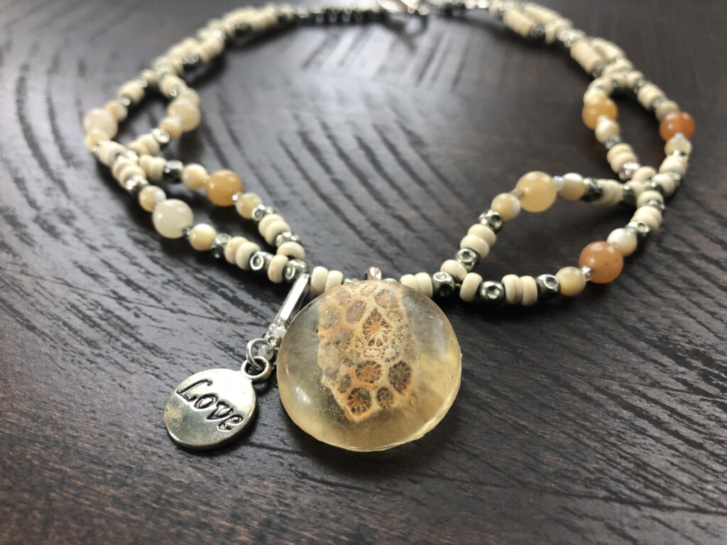 Beaded necklace with pendant of fossilized coral